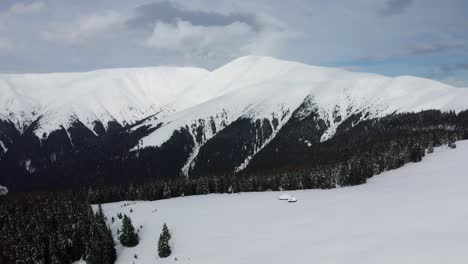 Winter-vista-of-Papusa-Peak-in-Iezer-Papusa-Mountains,-Arges,-Romania,-with-snow-covered-slopes-and-pine-trees