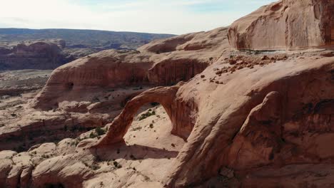 Eine-Hochfliegende-Drohnenaufnahme-Des-Corona-Bogens,-Eines-Massiven-Natürlichen-Sandsteinbogens-In-Einer-Seitenschlucht-Des-Colorado-River,-Westlich-Von-Moab,-Utah