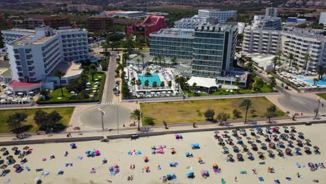 Drone-panning-from-the-left-going-to-the-right-side-of-the-frame-showing-the-whole-stretch-of-Cala-Mayor-beachfront-at-Palma-de-Mallorca,-located-in-the-Mediterranean-Sea