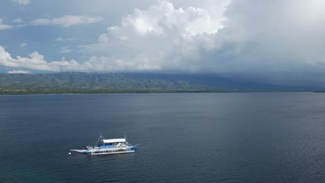 Aerial-drone-landscape-about-sailing-boat-floating-above-stormy-subtropical-southeast-asian-beach,-marine-seascape-environmental