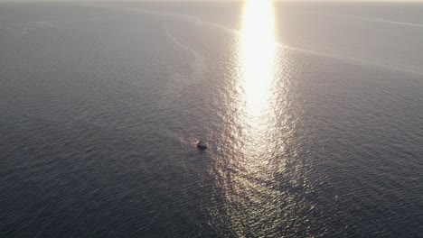 Aerial-view-of-fishing-boat-on-Mediterranean-Sea-at-sunset,-Sicily,-Italy