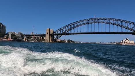 Establecer-Una-Panorámica-A-Través-Del-Puente-Del-Puerto-De-Sydney-Y-La-ópera-Bajo-Un-Cielo-Azul