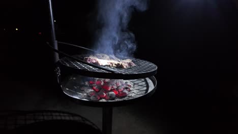 Rustic-Barbecue-Grill-Meat-On-Open-Fire-Coals-Outdoor-At-Night-In-Slow-Motion