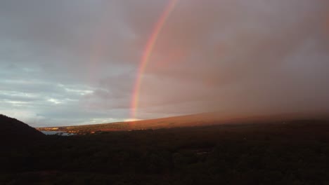 Stunning-aerial-shot-of-a-rainbow-over-beautiful-South-Maui-beach,-Maui-County,-Hawaii