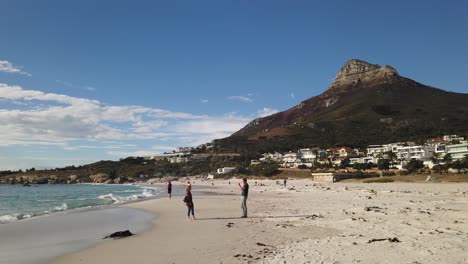 Cabeza-De-León-Vista-Desde-La-Playa-De-La-Bahía-Del-Campamento-Mientras-Los-Turistas-Toman-Fotografías-Junto-Al-Agua.