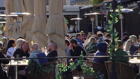 Happy-young-people-at-outdoor-bar-in-Stockholm,-traffic-in-foreground