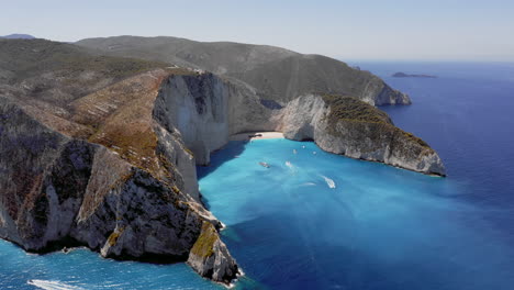 Aerial:-Panoramic-orbit-shot-of-Navagio-beach-in-Zakynthos-with-the-famous-wrecked-ship