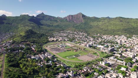 The-citadel-and-port-louis-in-mauritius,-lush-mountains-surrounding-urban-landscape,-sunny-day,-aerial-view