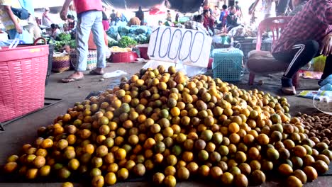 A-presentation-of-mountain-mandarin-oranges-showcased-alongside-a-price-label,-with-individuals-in-the-surrounding-scene