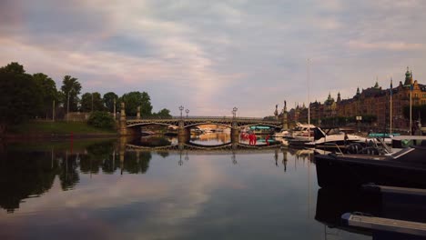 Old-bridge-Djurgardsbron-and-still-water-in-Stockholm,-summer-morning