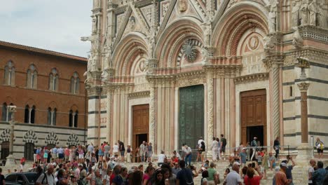 Lapso-De-Tiempo-De-Inclinación-Lenta-De-La-Catedral-De-Siena-En-Italia-Mientras-Turistas-Y-Estudiantes-Se-Reúnen-En-La-Calle-Y-Toman-Fotografías