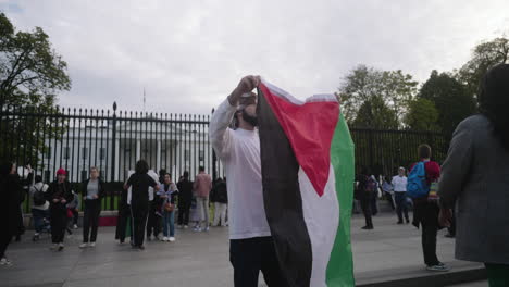 Un-Hombre-árabe-Ondeando-Una-Bandera-Palestina-Frente-A-La-Casa-Blanca-En-D