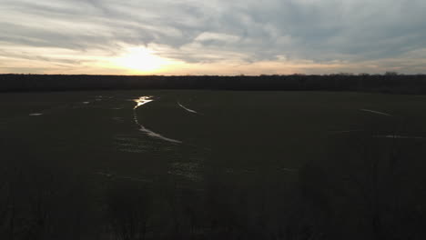 Sunset-at-Loosahatchie-Park,-TN,-with-a-serpentine-river-gleaming-through-the-fields,-aerial-view