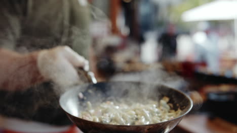 Chef-Lanzando-Una-Sartén-De-Fideos-Humeante-En-La-Cocina-Del-Festival
