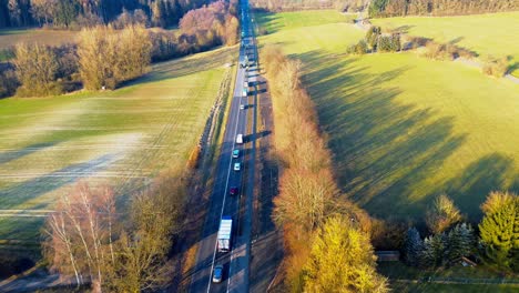 Goldene-Stunde-über-Einer-Ruhigen-Landstraße-Inmitten-Hügeliger-Felder