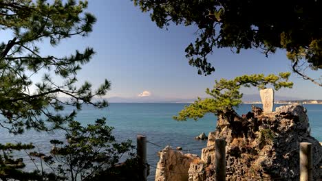 Mount-Fuji-behind-ocean-as-seen-between-beautiful-Japanese-pine-trees