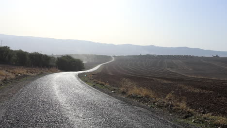 Kurvenreiche-Straße-Durch-Sonnenbeschienene-Tunesische-Landschaft,-Frühes-Morgenlicht,-Klarer-Himmel