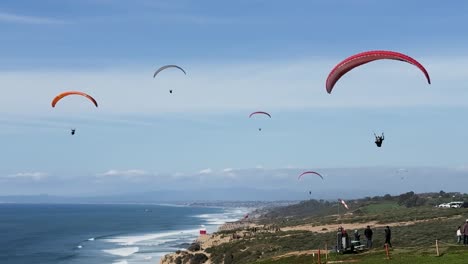 Muchos-Parapentes-Volando-Cuando-Un-Parapente-En-Tándem-Que-Vuela-De-Cerca-Llega-Para-Un-Aterrizaje-Suave-En-El-Planeador-Torrey-Pines-En-La-Jolla,-California