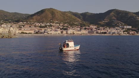 Aerial-view-of-fishing-boat-on-Mediterranean-Sea-at-sunset,-Sicily,-Italy