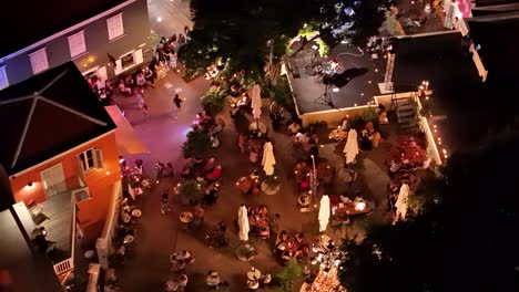 Aerial-orbit-around-families-enjoying-night-out-at-open-air-cafe-in-Kura-Hulanda-village-in-Otrobanda-Willemstad-Curacao