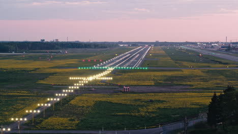 Volando-Alrededor-De-La-Zona-De-Aterrizaje-De-La-Pista-Del-Aeropuerto-De-Tallin-Al-Atardecer-Con-Las-Luces-De-Aproximación-Encendidas-Y-Los-Destellos-Rodantes