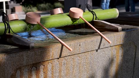 Typische-Japanische-Wasserschöpfkellen,-Die-Am-Shinto-Schrein-Zurückgelassen-Wurden,-Wo-Sich-Menschen-Reinigen