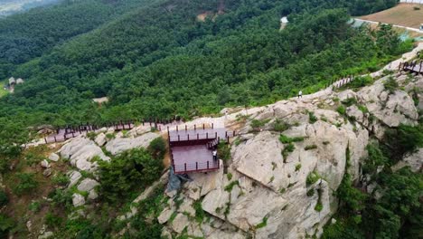 Dynamic-aerial-forward-wide-panoramic-view-of-black-guy-flying-drone-at-Weihai-Huaxia-Cheng,-China