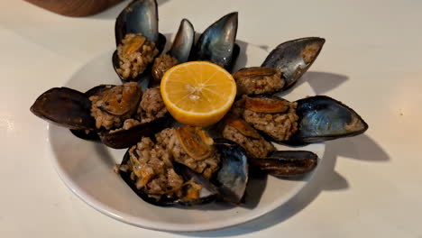 Close-up-shot-of-a-plate-of-grilled-black-oysters-with-orange-flavor,-restaurant