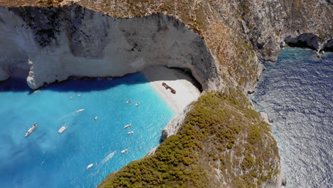 Aerial:-Panoramic-orbit-view-of-Navagio-beach-in-Zakynthos-island,-Greece