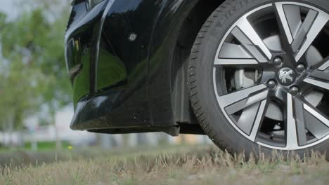 Close-up-shot-at-ground-level-of-a-Peugeot-car-wheel-backing-away