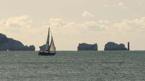 Segelboot-Segelt-Den-Solent-Mit-Den-Isle-Of-Wight-Needles-Im-Hintergrund,-Gefilmt-In-Milford-On-Sea