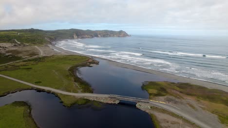 Panoramic-drone-shot-of-the-coastline-of-Cucao,-partly-sunny-Chiloé,-Chile
