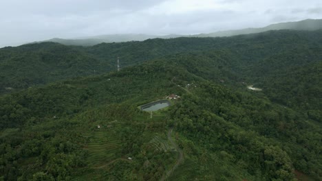 Aerial-view-of-water-reservoir-in-the-middle-of-hills-forest