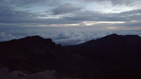 Atemberaubender-Zeitraffer-Einer-Morgendämmerung-Mit-Sonne,-Krater-Und-Bauschiger-Wolkendecke-Auf-Dem-Gipfel-Des-Vulkans-Im-Haleakala-Nationalpark,-Einem-Riesigen-Schildvulkan,-Maui,-Hawaii,-USA