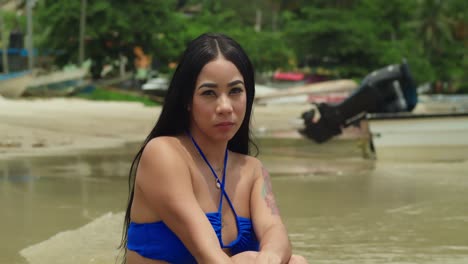 Her-blue-thong-bikini-shimmering-in-the-Caribbean-sunlight-amidst-the-tropical-splendor-of-Maracas-Beach,-a-radiant-Latina-revels-in-the-island's-beauty