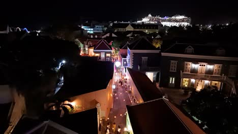 Aerial-dolly-above-Kura-Hulanda-village-in-Otrobanda-Willemstad-Curacao-side-street-at-night-with-romantic-lights