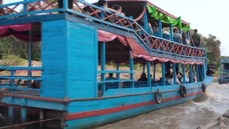 In-Kampong-Phluk-Villages,-a-mesmerizing-sight-unfolds-as-a-variety-of-local-small-and-larger-boats-navigate-and-cruise-along-the-tranquil-waters-of-the-Mekong-Delta-River