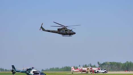 Canadian-military-helicopter-fly-off-to-assist,-handheld-view