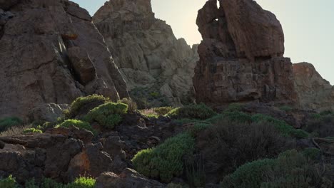 Scenic-view-of-rock-formations-with-sun-rays-in-Teide-National-Park,-dynamic-tilting-upward