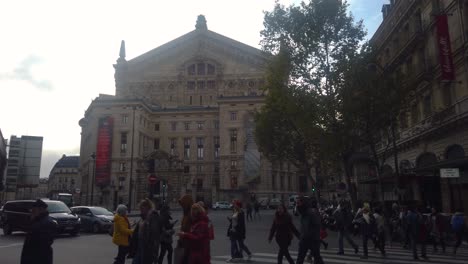 Toma-En-Cámara-Lenta-De-Gente-Caminando-Por-La-Calle-Frente-Al-Palacio-Garnier-En-París.