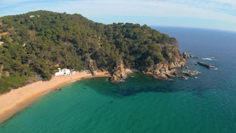 Aerial-footage-captures-the-allure-of-Lloret-De-Mar's-coastline,-adorned-with-Cala-Canyelles'-beauty,-nestled-in-the-heart-of-Costa-Brava