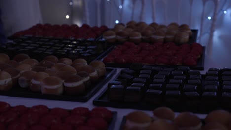 Slow-pull-out-shot-of-a-large-selection-of-homemade-deserts-at-a-wedding-buffet