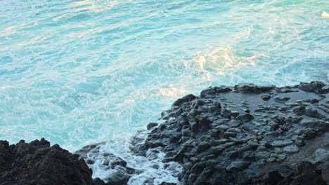 Salpicaduras-De-Agua-Golpeando-Las-Rocas-En-La-Orilla-Del-Mar,-Cierre-Estático-En-Cámara-Lenta