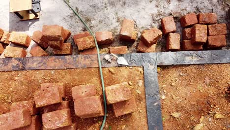 Workers-work-at-a-construction-site-in-India,-Construction-using-earthen-blocks,-Building-the-foundation-of-the-house,-Building-a-house-with-red-stone-,-Works-using-cement-