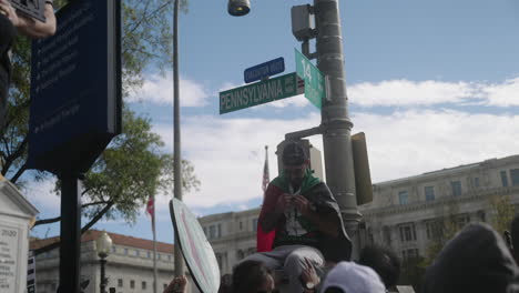 An-Arab-Man-Sitting-on-a-Street-Light-on-Pennsylvania-Avenue-Ties-on-a-Palestinian-Flag