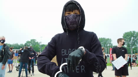 Handcuffs-are-taken-off-by-Asian-man-wearing-hoody-and-mask,-symbol-of-freedom