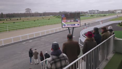 Público-Viendo-Una-Competición-De-Caballos-De-Carreras-Desde-La-Tribuna.