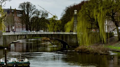 Time-lapse-of-people-and-cars-crossing-bridge-over-river-in-Den-Bosch,-the-Netherlands---wide-pan