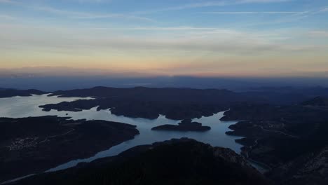 See-Kerkinis-Mit-Weitläufigen-Flussmündungen-Entlang-Des-Randes,-Während-Sich-Ein-Blau-gelber-Farbverlauf-über-Den-Himmel-Ausbreitet