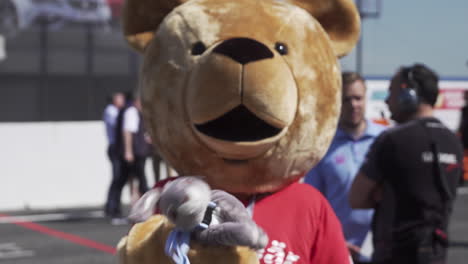Mascot-in-a-bear-costume-jokingly-dancing-for-the-cameras-at-a-racing-event